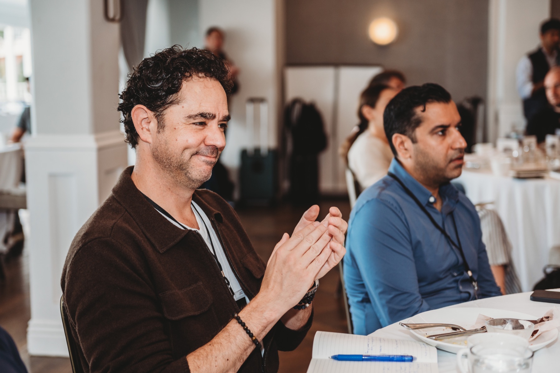 A FIRE Summit 2025 attendee applauding during a session