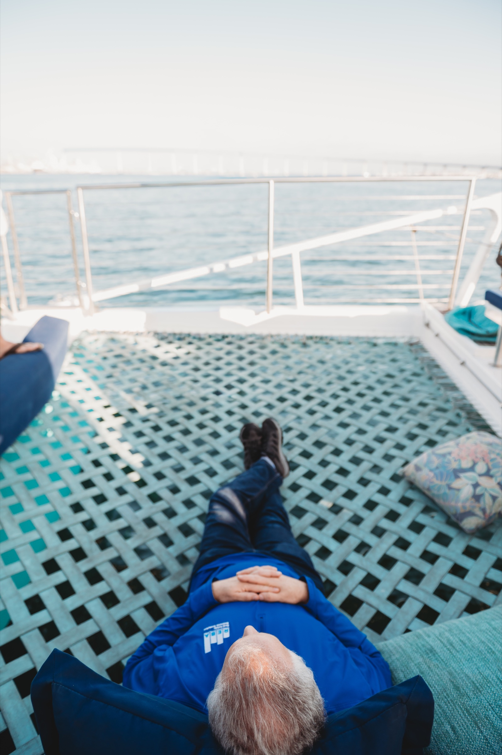 A FIRE Summit 2026 attendee relaxing on the boat's net above the water